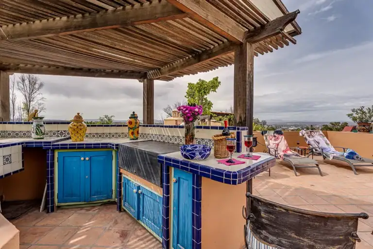 Casa DeeDee, rooftop outdoor kitchen with blue cabinets under a pergola, San Miguel de Allende