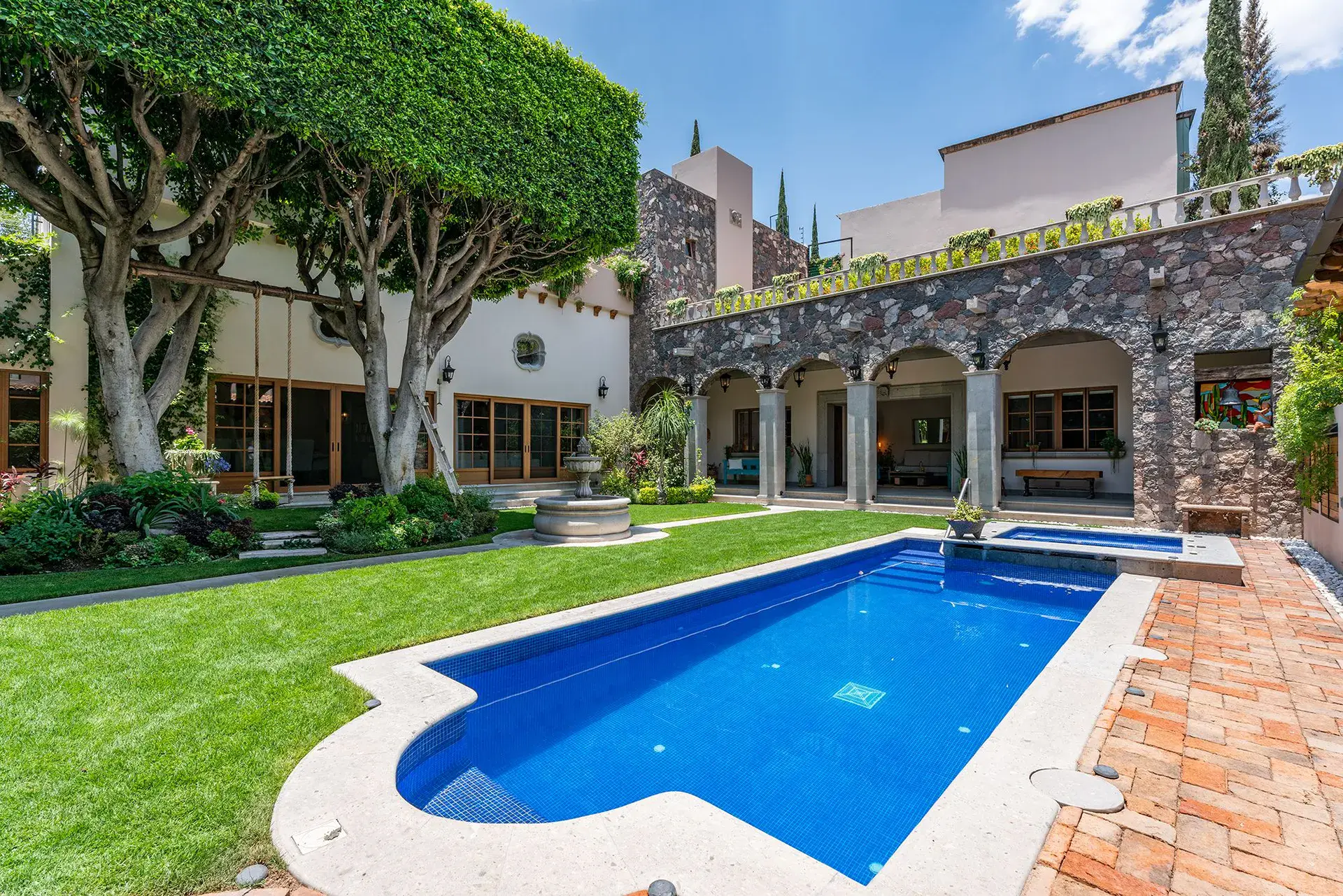 Casa del Angel, blue pool with a curved end beside the lawn and arcade, San Miguel de Allende