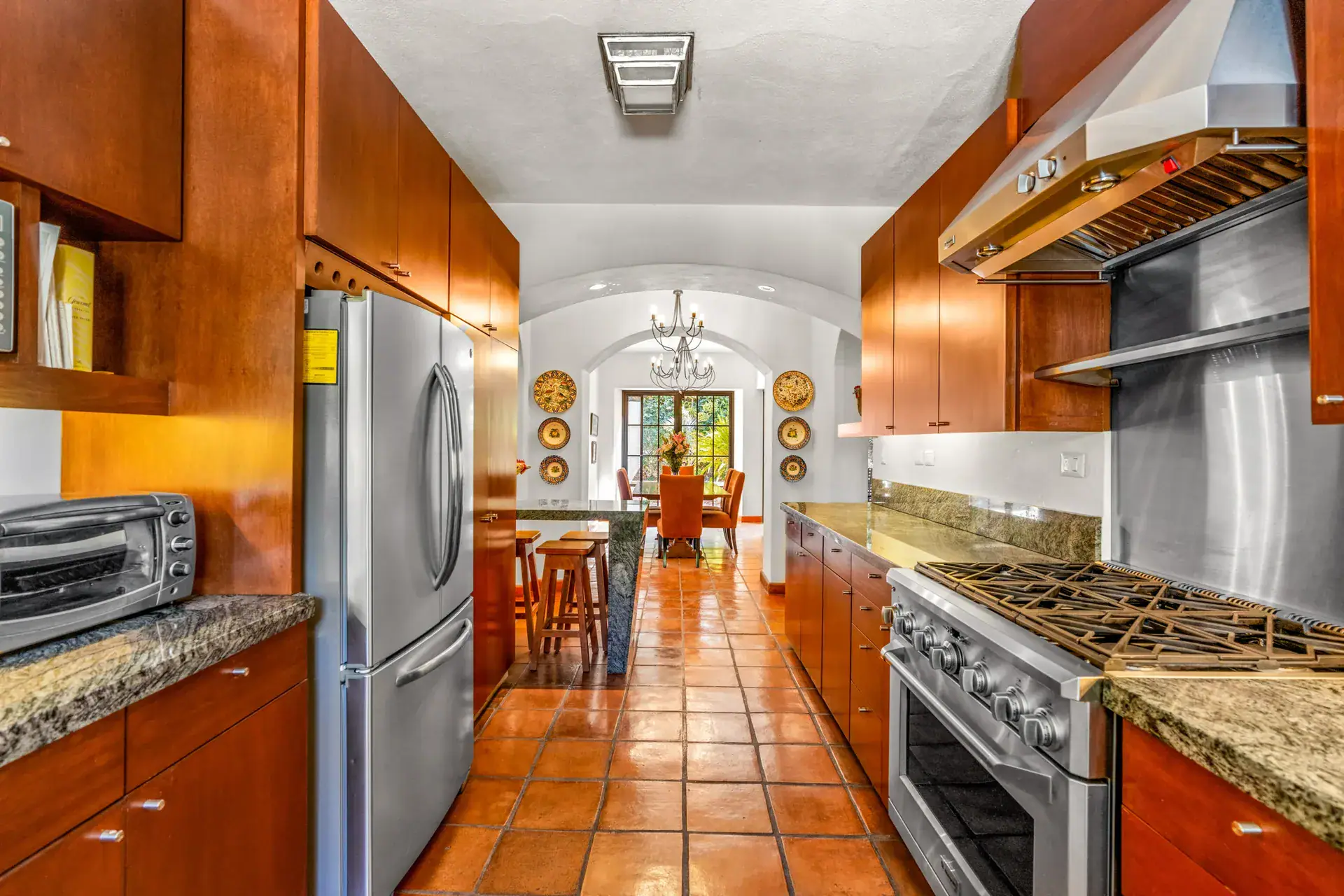Casa del Artista, kitchen with a stainless refrigerator, a professional range with a steel hood and a view to the dining room, San Miguel de Allende