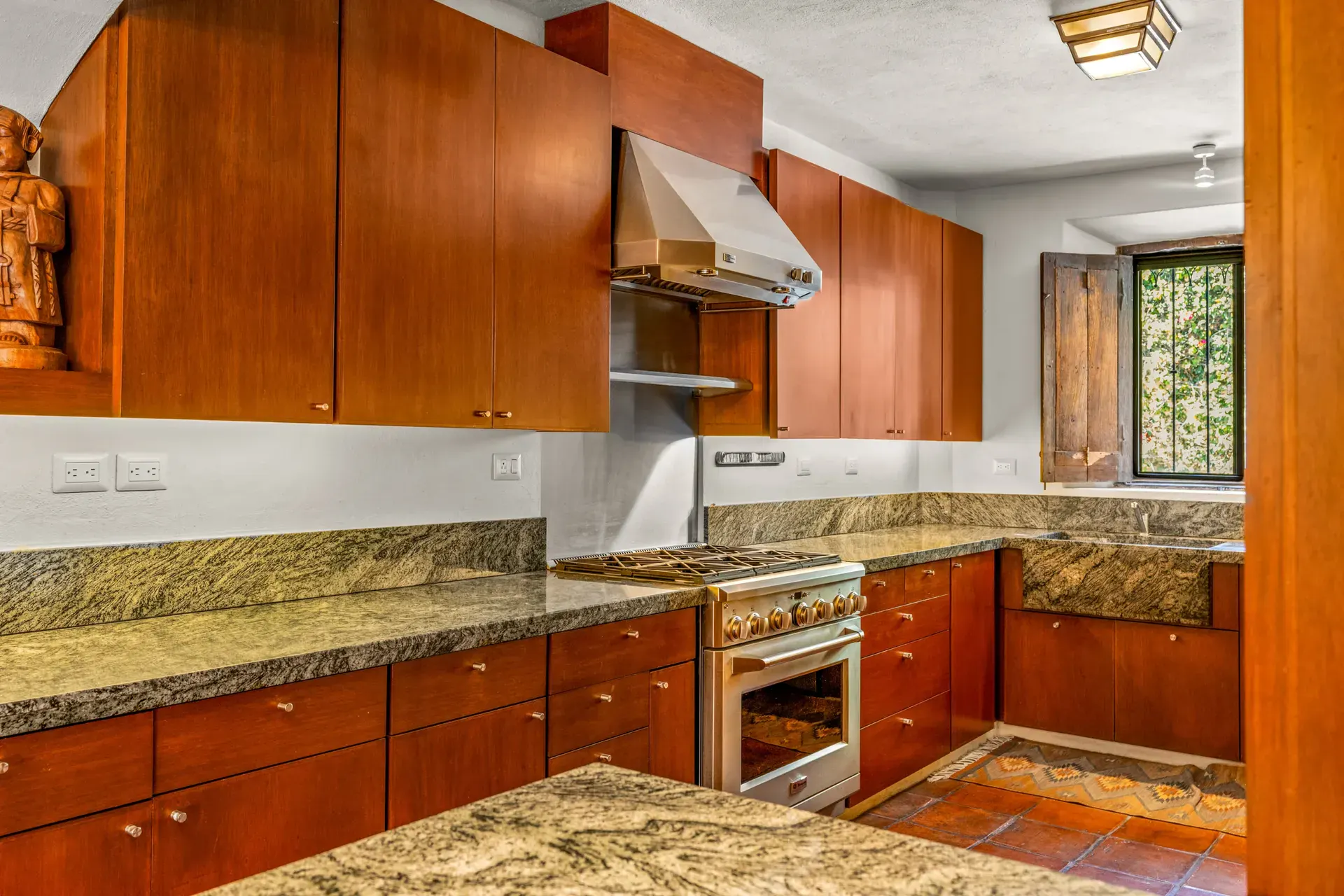 Casa del Artista, kitchen with cherry cabinets, a gas range, a stainless hood and green granite counters, San Miguel de Allende