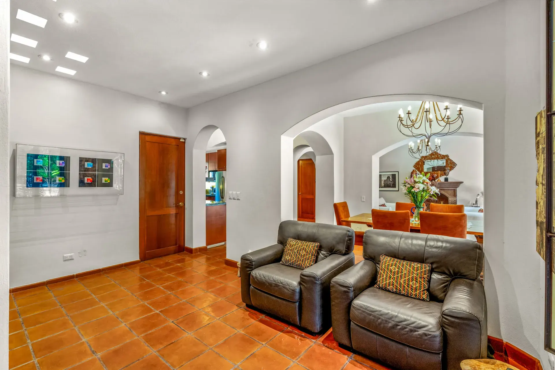 Casa del Artista, den with two leather recliners, an arch to the dining room and a wood door, San Miguel de Allende