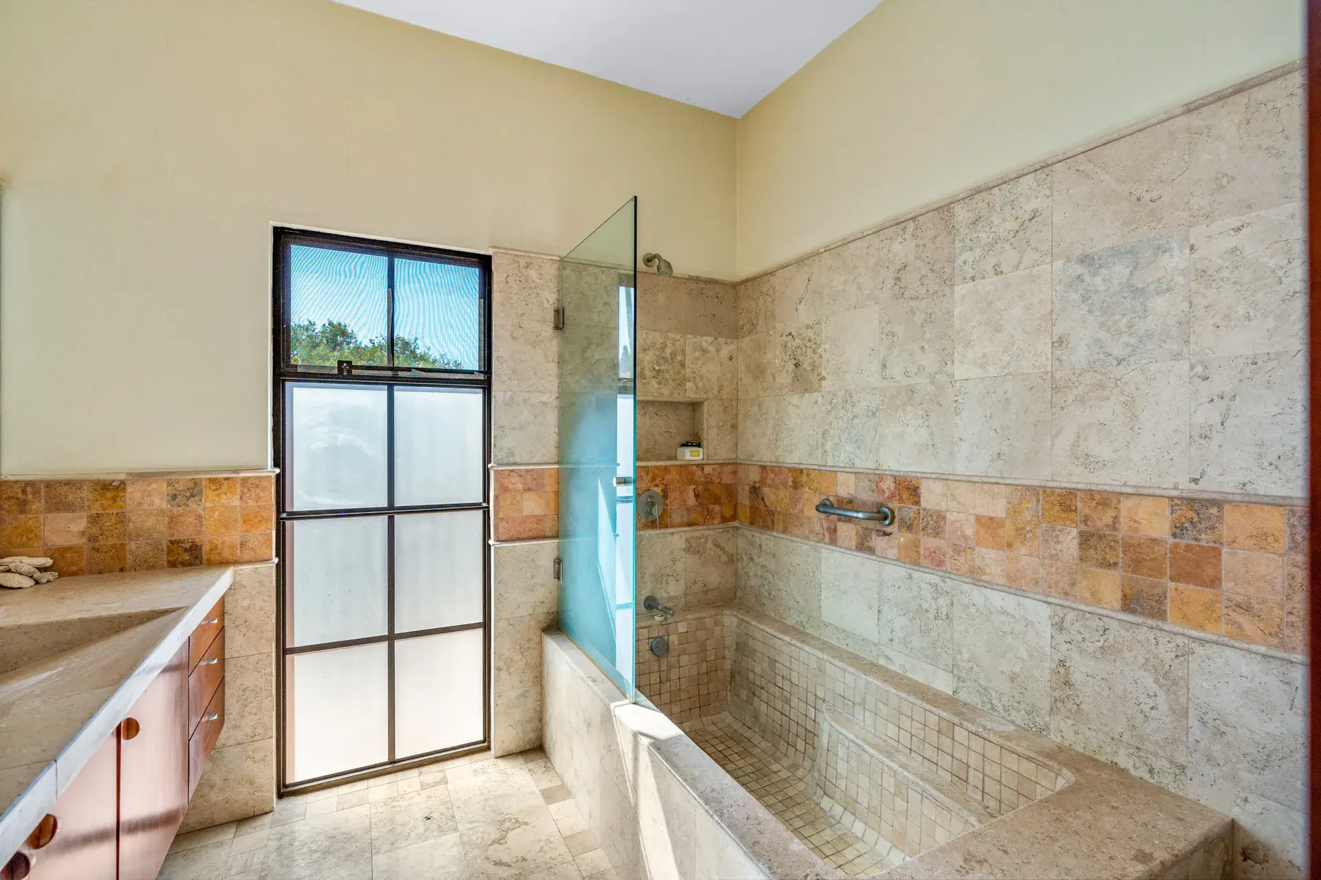 Casa del Artista, bathroom with a corner tub, tiled shower and a frosted black-framed window, San Miguel de Allende