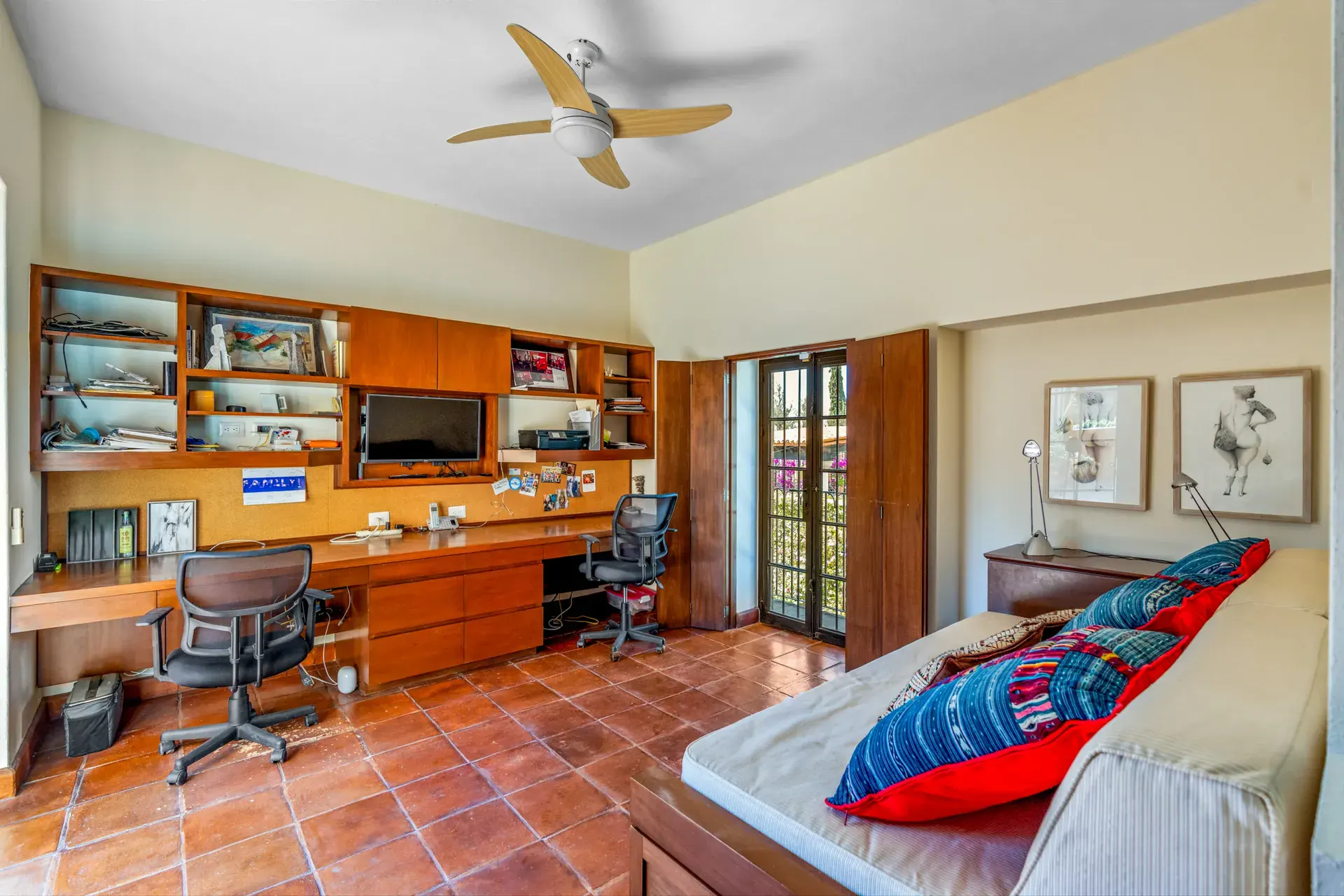Casa del Artista, home office with a built-in wood desk, shelves, a television and a daybed with colorful pillows, San Miguel de Allende