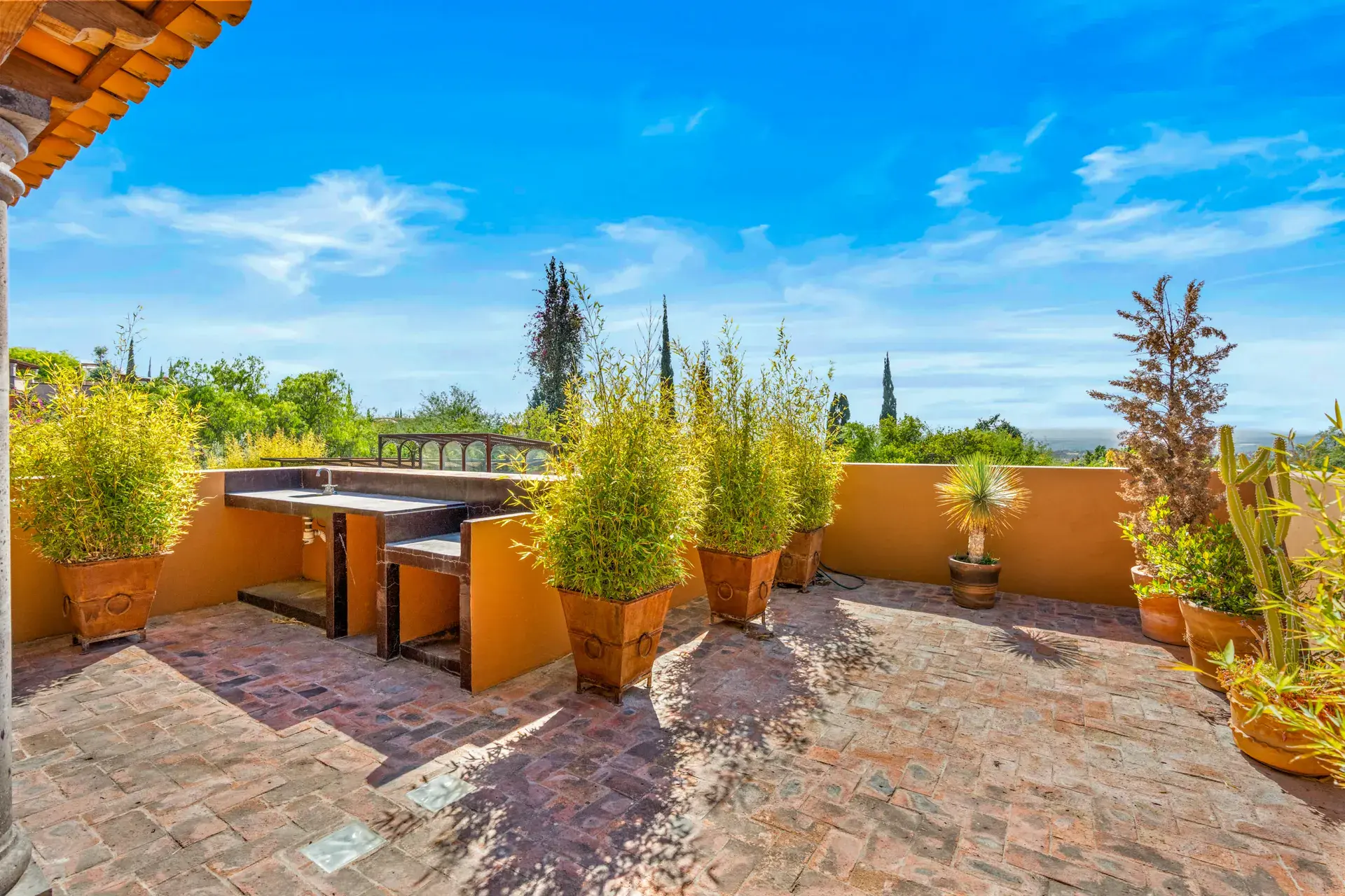 Casa del Artista, rooftop terrace with a built-in dining counter, bamboo planters and a view of the valley, San Miguel de Allende