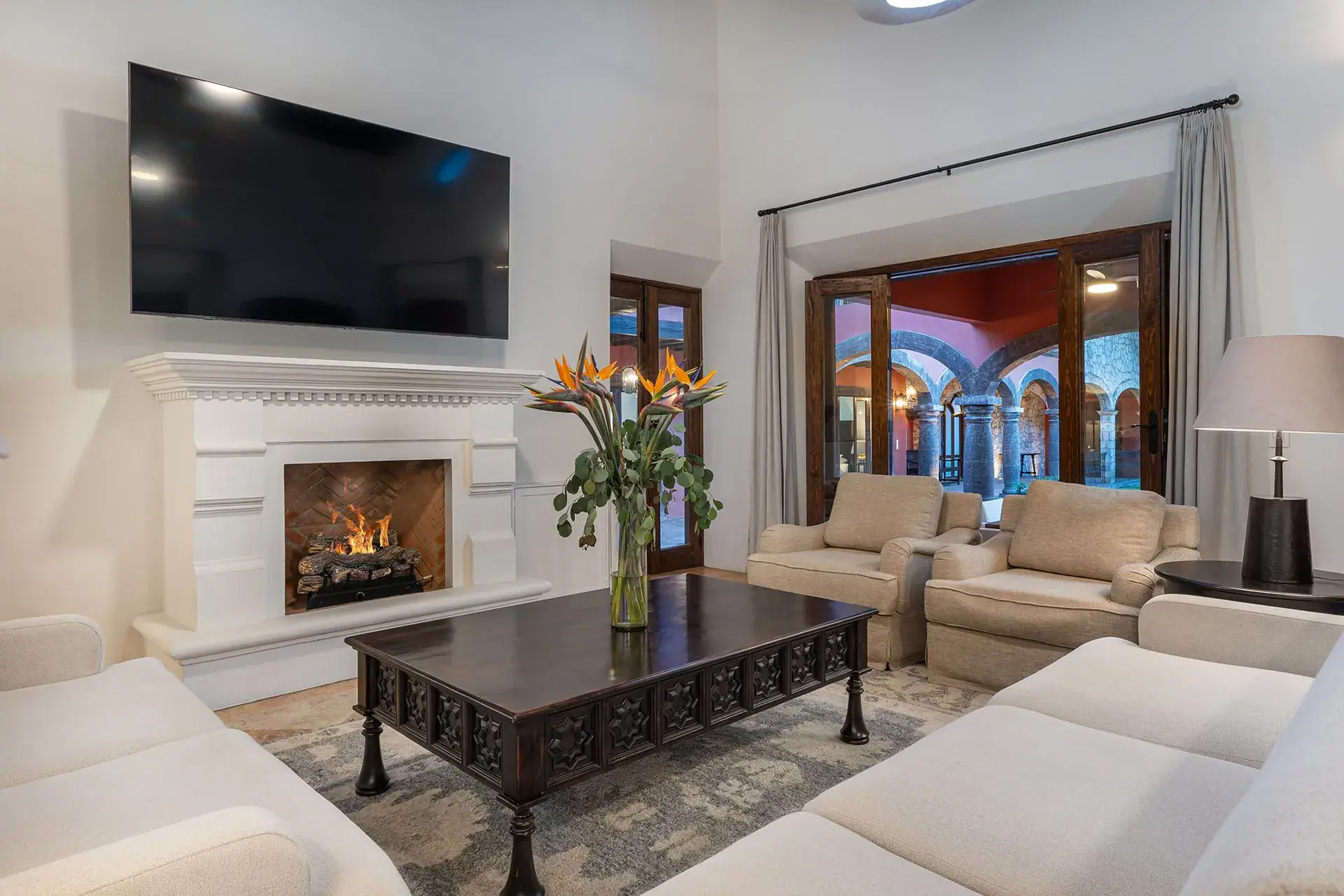 Casa Del Cardo, living room with a white fireplace and a wall-mounted television, San Miguel de Allende