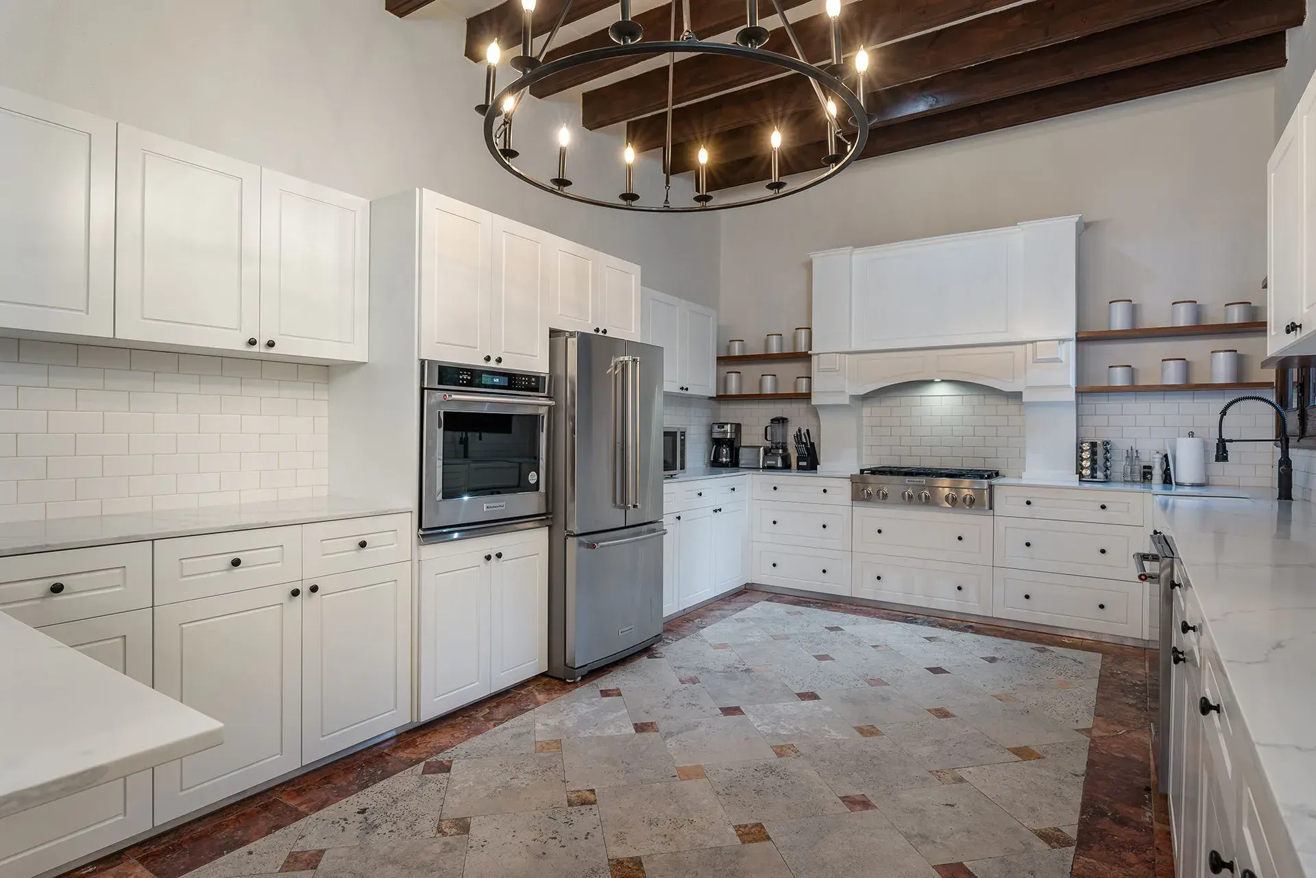 Casa Del Cardo, kitchen with white cabinets, an iron chandelier and a terracotta floor, San Miguel de Allende