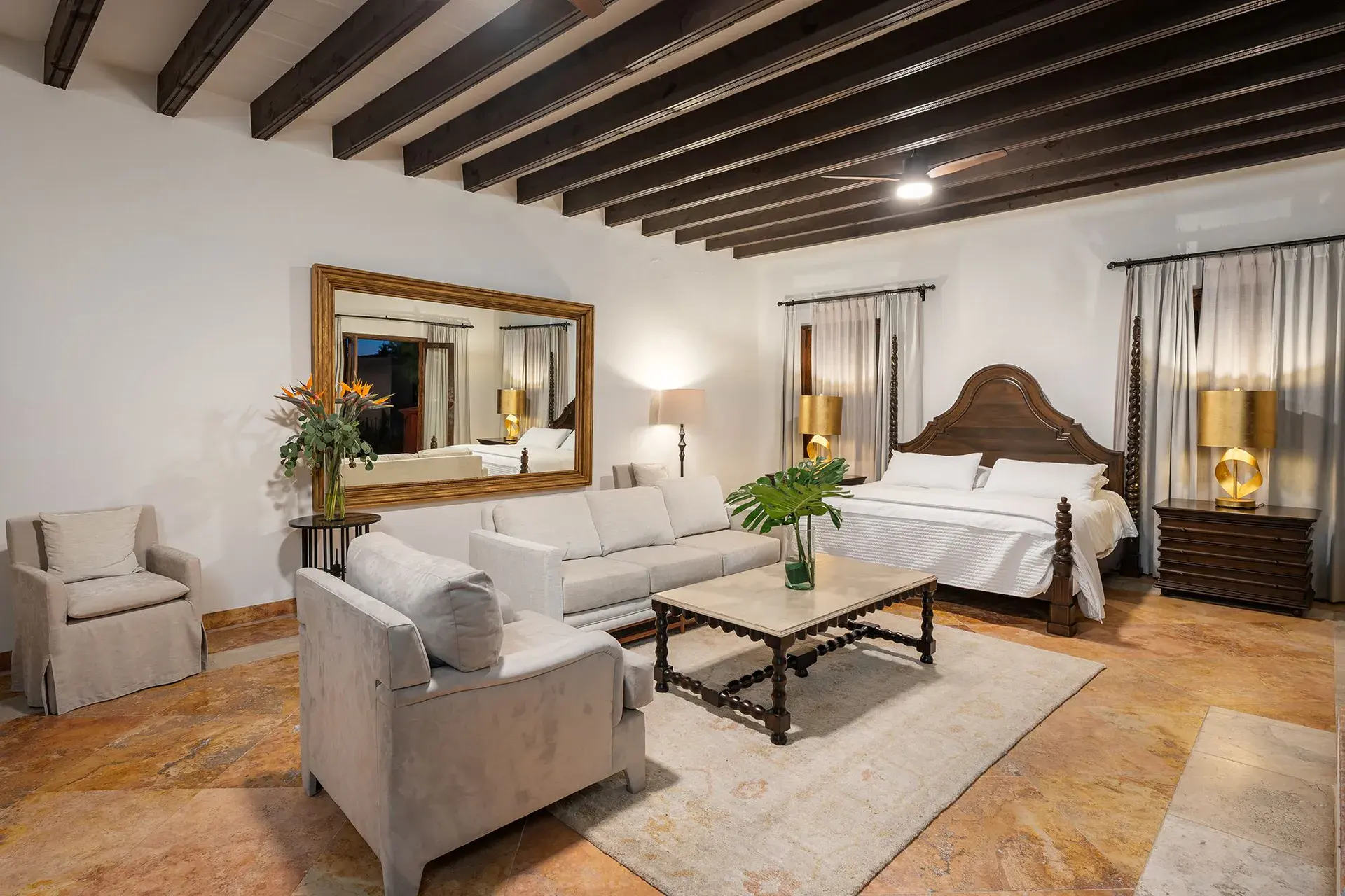 Casa Del Cardo, primary suite with a carved wood headboard and a sofa seating area, San Miguel de Allende