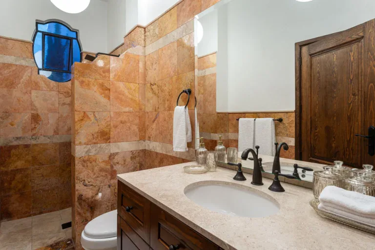 Casa Del Cardo, bathroom with a stone vanity and terracotta tile walls, San Miguel de Allende