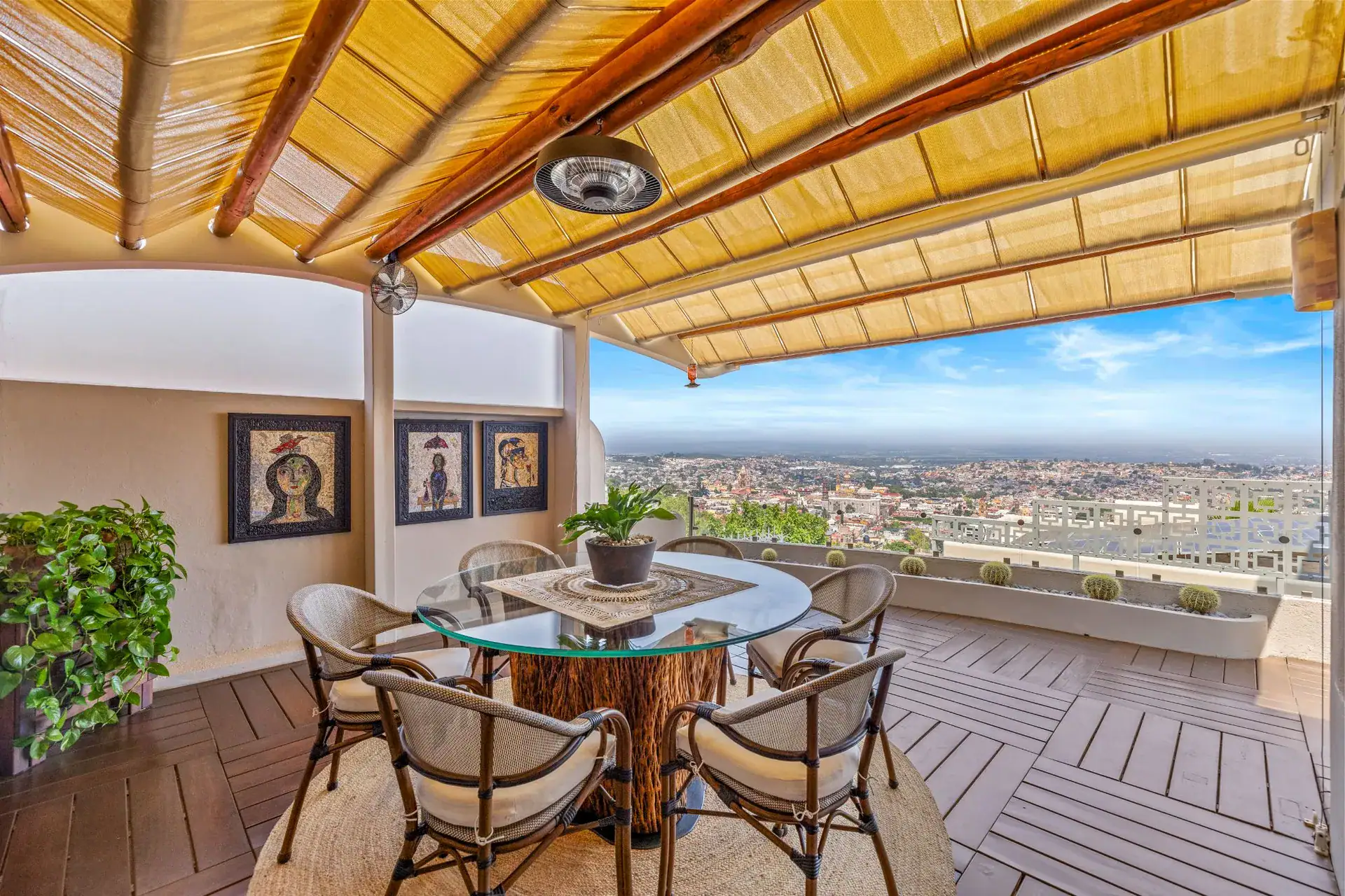 Casa del Foro, terrace dining table with a bamboo and wood ceiling, framed portraits and a town view, San Miguel de Allende