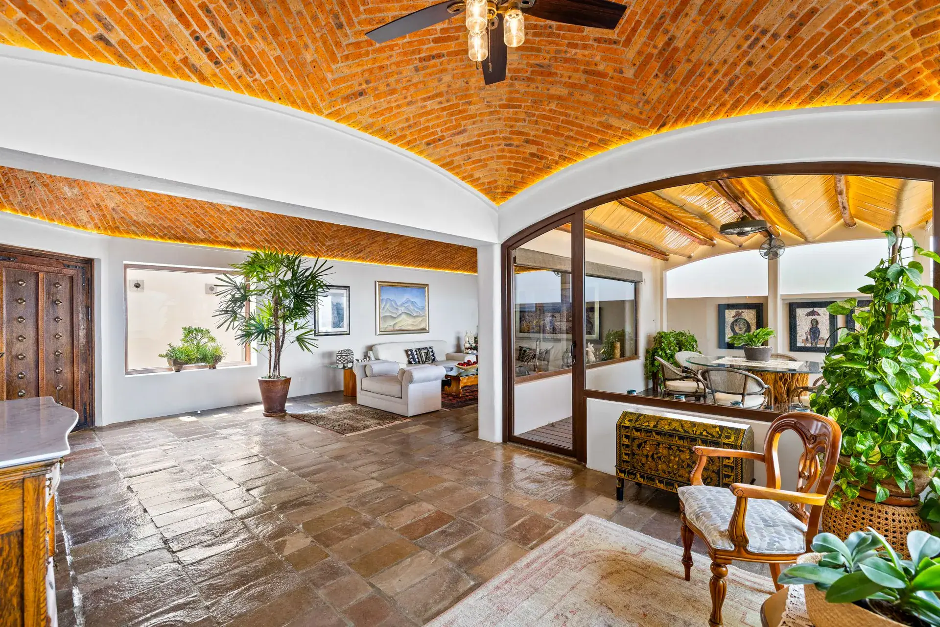 Casa del Foro, living room and terrace beyond arched glass doors under a brick vaulted ceiling, San Miguel de Allende