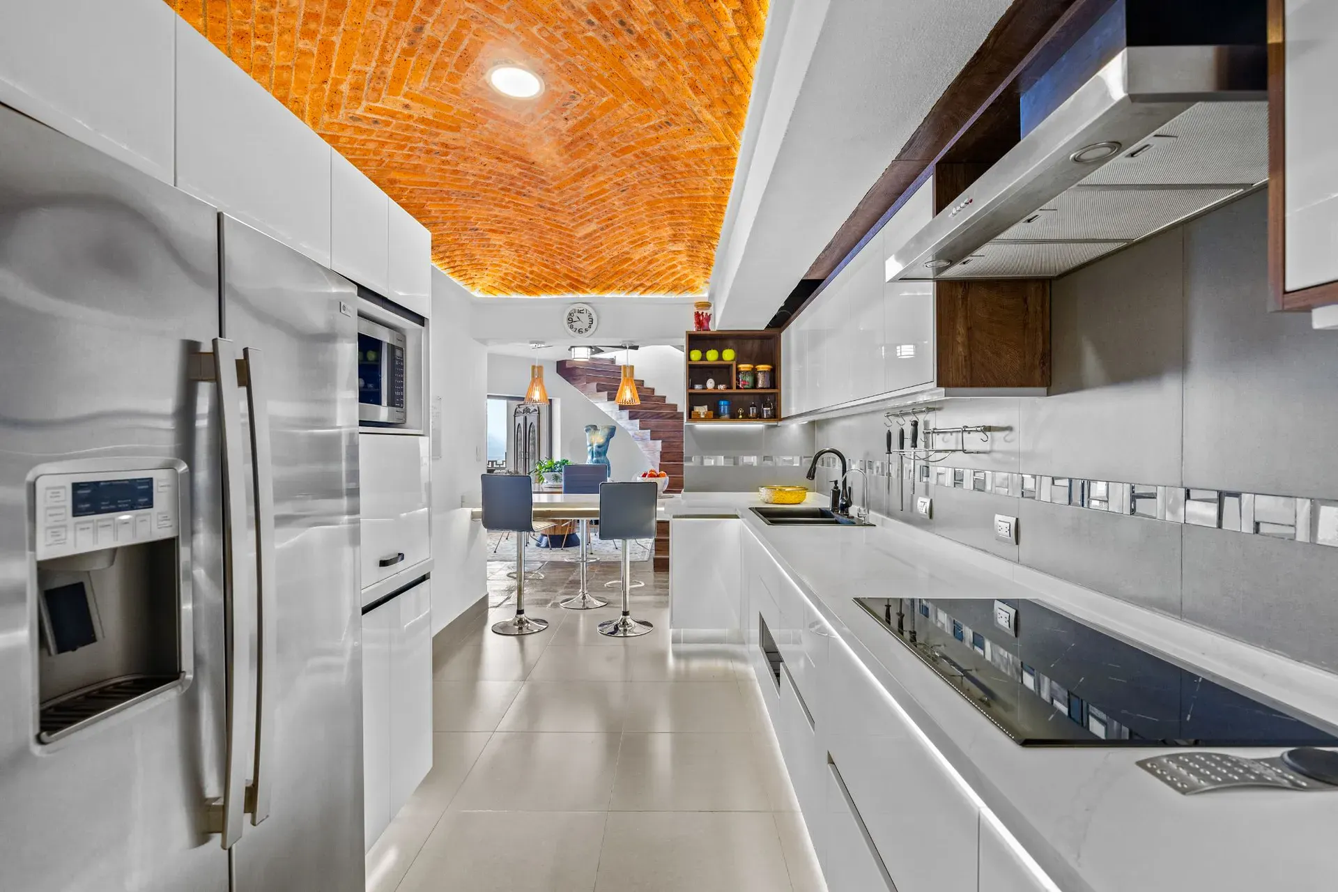 Casa del Foro, kitchen with a stainless refrigerator, a black induction cooktop and a brick vaulted ceiling, San Miguel de Allende