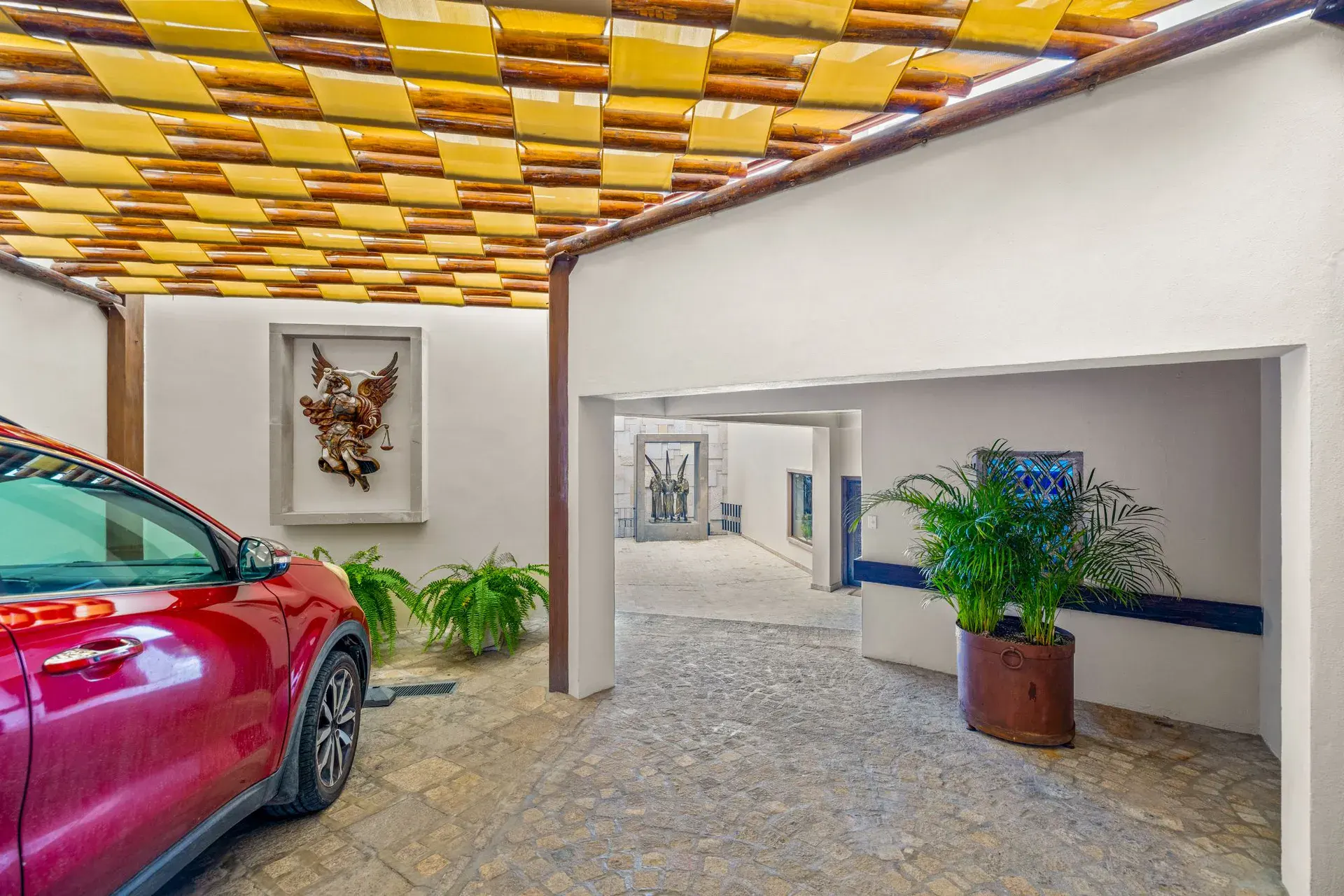 Casa del Foro, covered driveway with a checkerboard ceiling and a car parked beside a courtyard, San Miguel de Allende