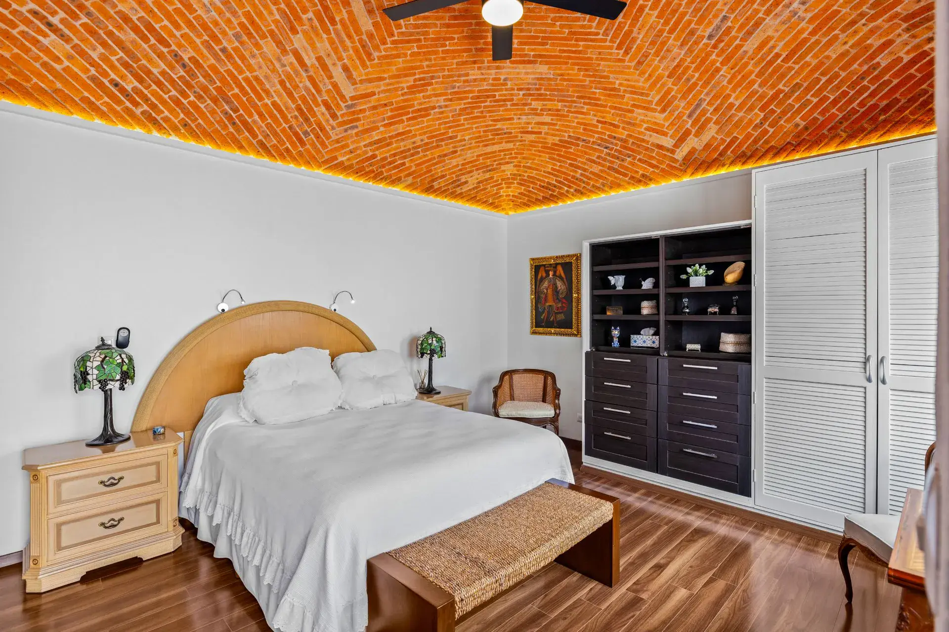 Casa del Foro, bedroom with a round headboard, a stained glass lamp and built-in shelves, San Miguel de Allende