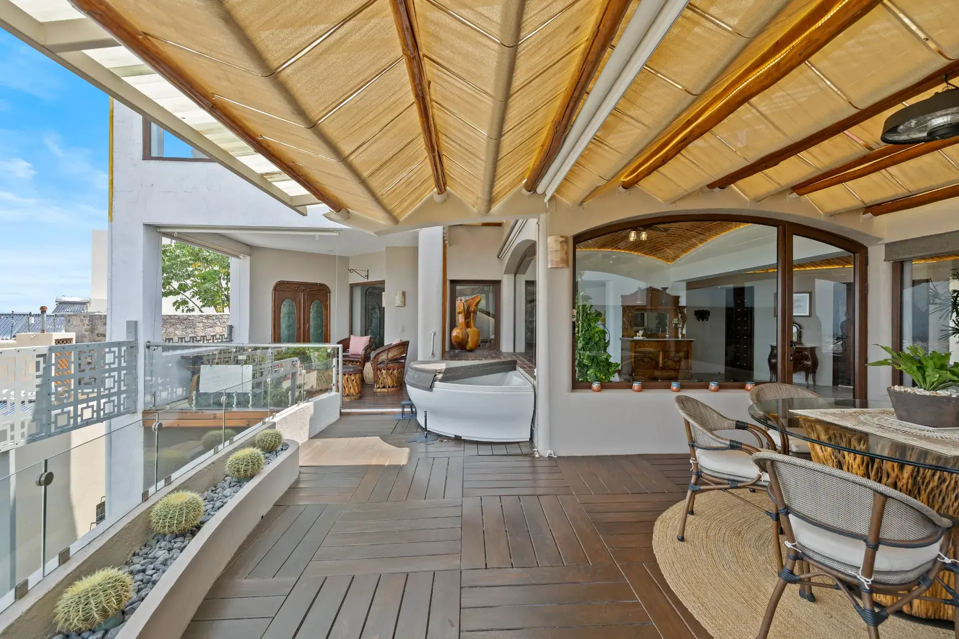 Casa del Foro, covered terrace with a wood deck, dining chairs, a bar counter and glass railings, San Miguel de Allende