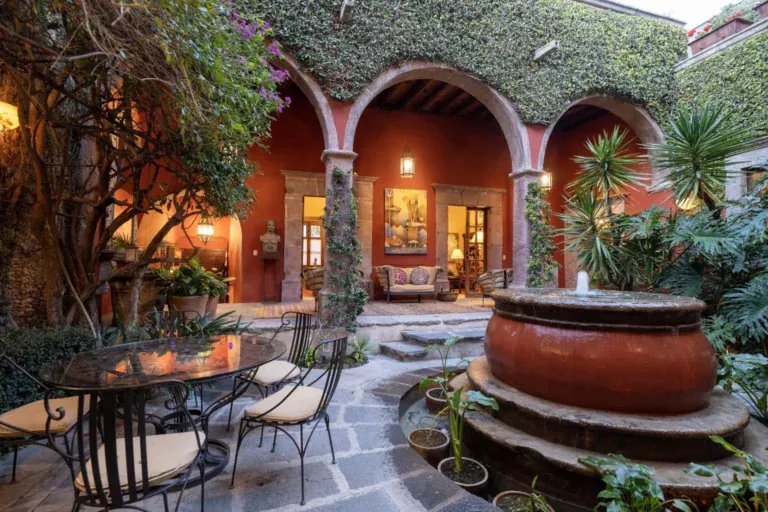 Casa Diana, arcaded courtyard with a terracotta fountain and an outdoor dining set, San Miguel de Allende