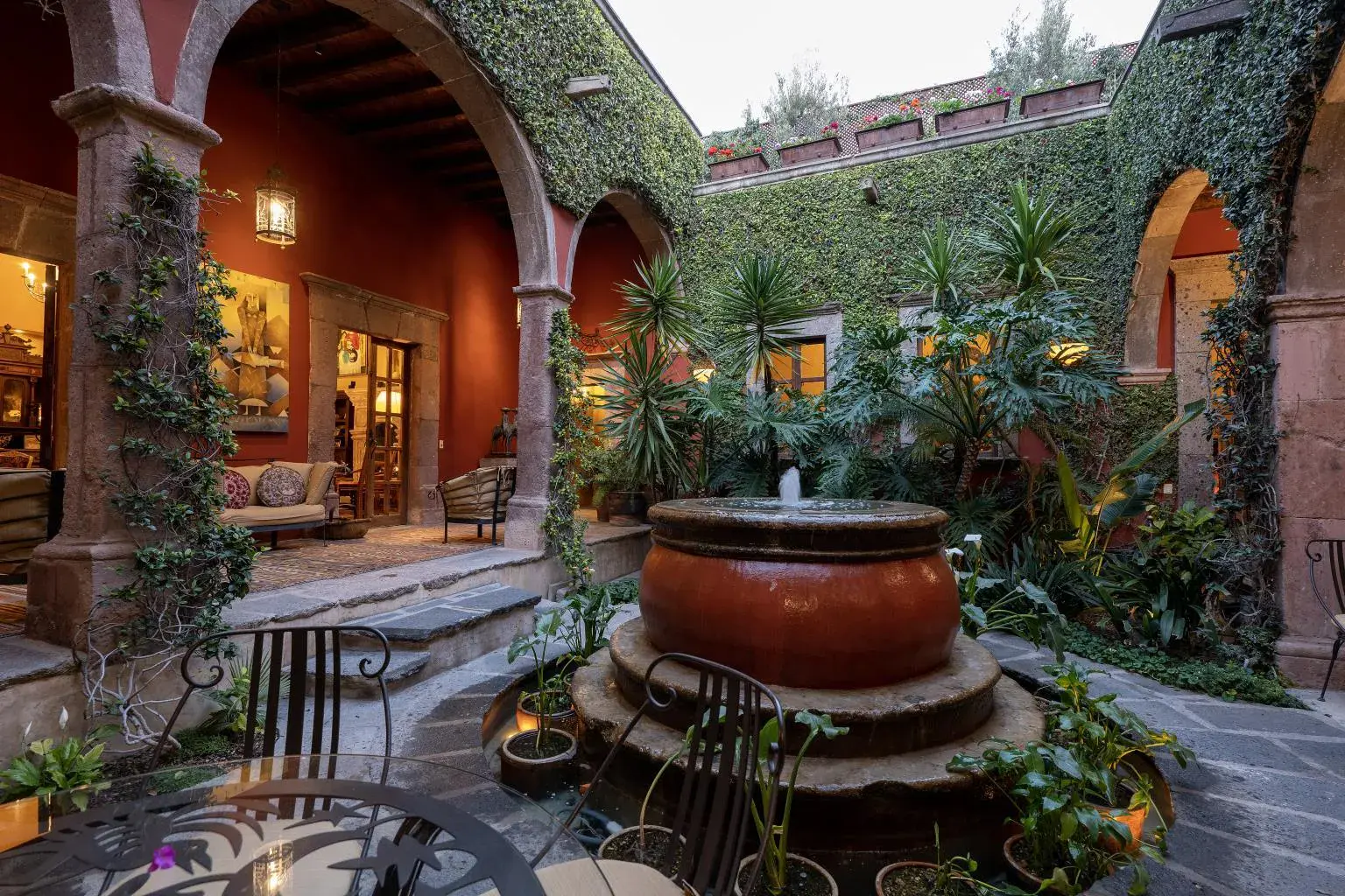 Casa Diana, courtyard with a large clay fountain under a vine-covered wall, San Miguel de Allende