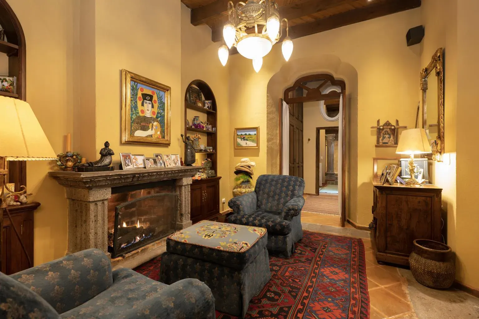 Casa Diana, living room with a fireplace, patterned armchairs and a beamed ceiling, San Miguel de Allende