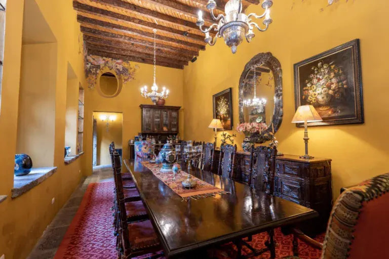 Casa Diana, dining room with a long wood table, chandelier and framed art, San Miguel de Allende