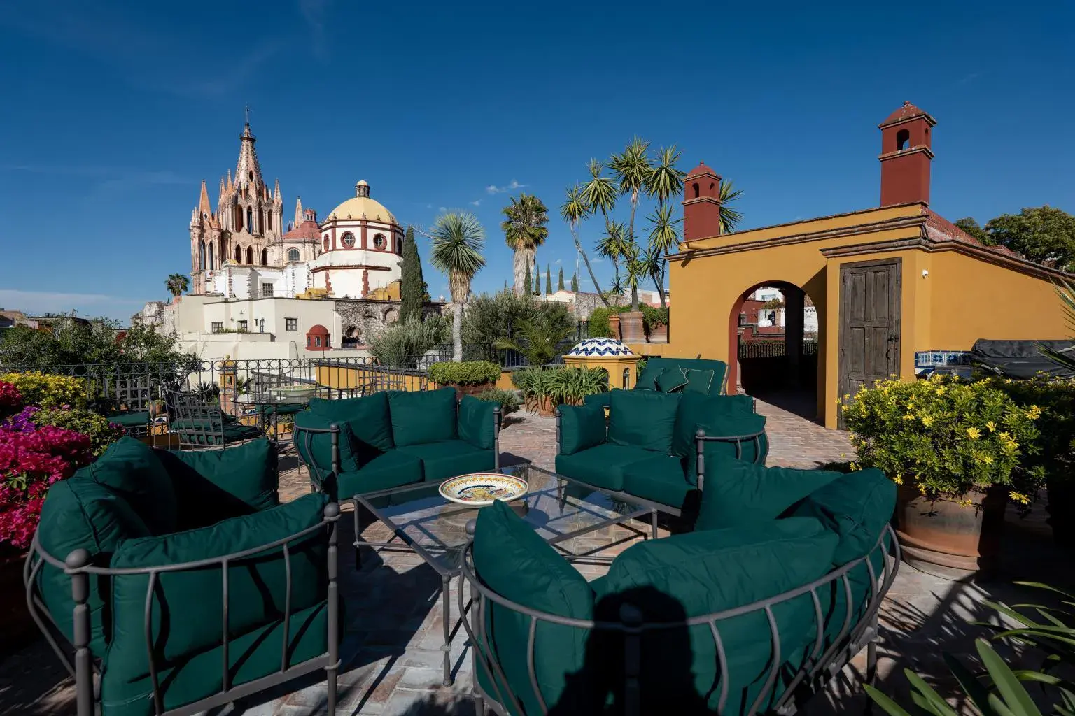 Casa Diana, rooftop terrace with green sofas and a view of the Parroquia, San Miguel de Allende