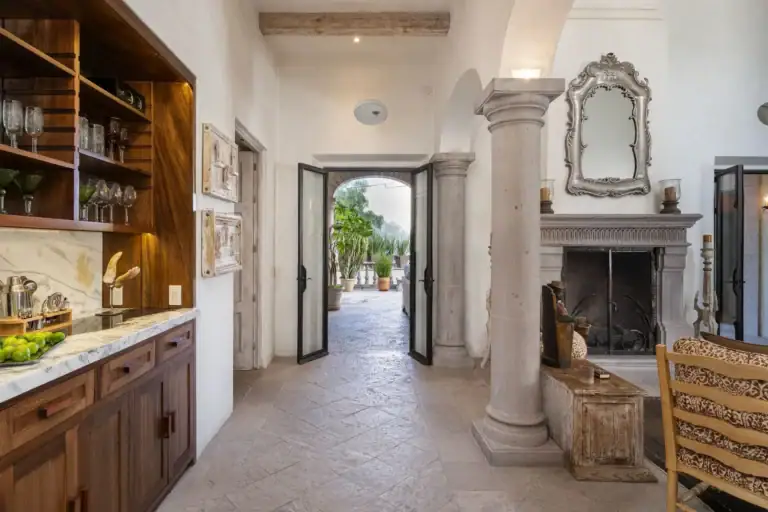 Casa Dos Casas, entry hall with a wet bar and shelves of glassware leading to an open courtyard door, San Miguel de Allende