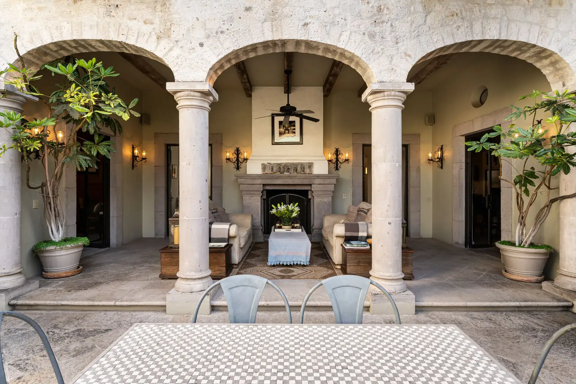 Casa Dos Casas, arched loggia with stone columns, a fireplace and seating facing the courtyard, San Miguel de Allende