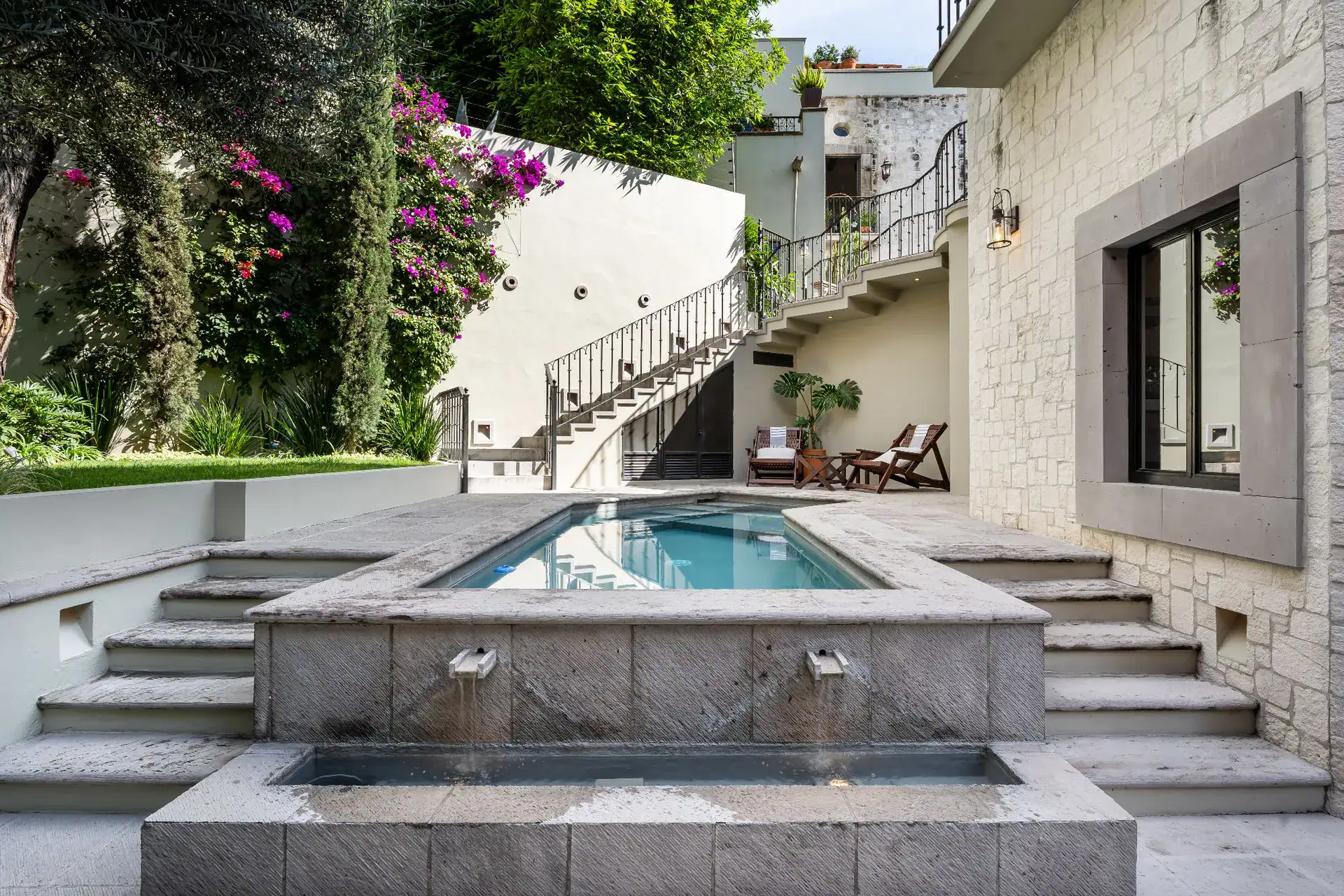 Casa Dos Casas, raised pool with a fountain, stone steps and a curved staircase in the courtyard, San Miguel de Allende