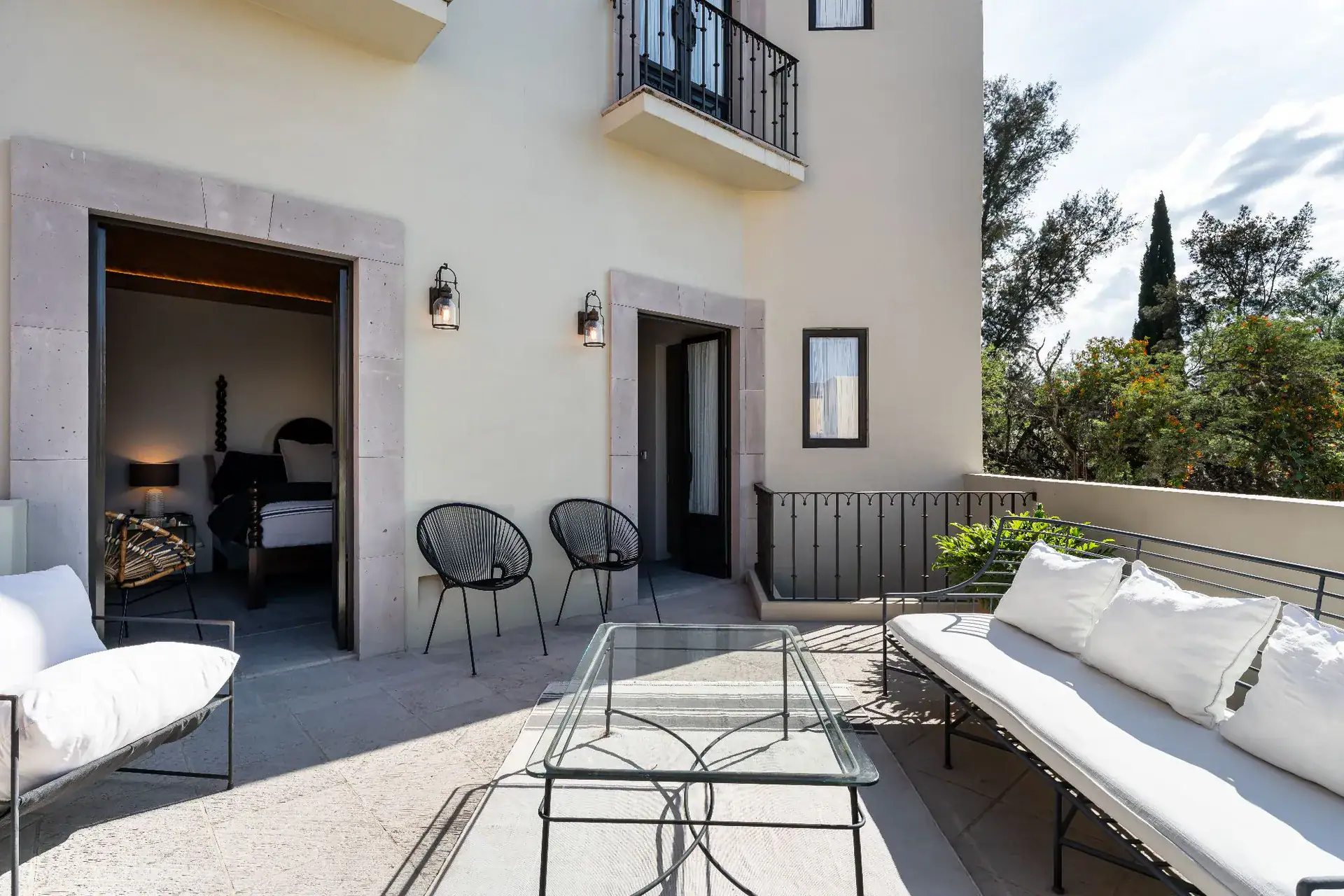 Casa Dos Casas, terrace with white outdoor seating and black chairs outside a bedroom door, San Miguel de Allende