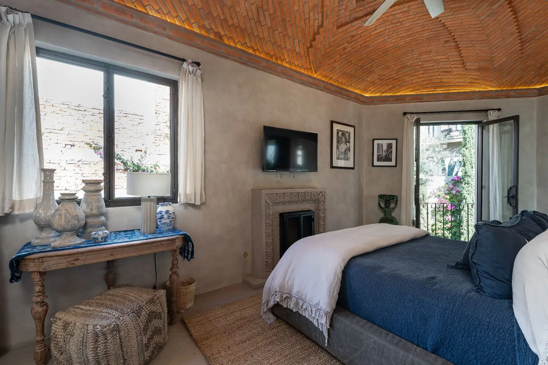 Casa Dos Casas, bedroom with a blue bedspread, console table and a brick vaulted ceiling, San Miguel de Allende