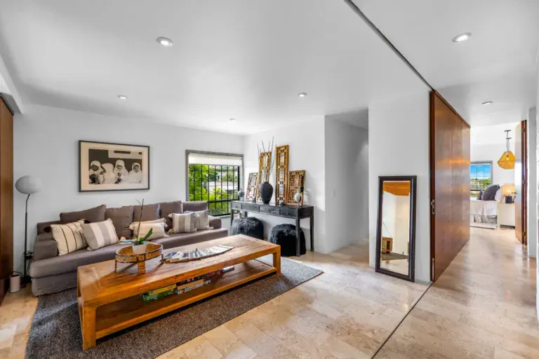 Casa Dos Gatos, upper sitting room with a brown sofa, a wood coffee table and a sliding wood door, San Miguel de Allende