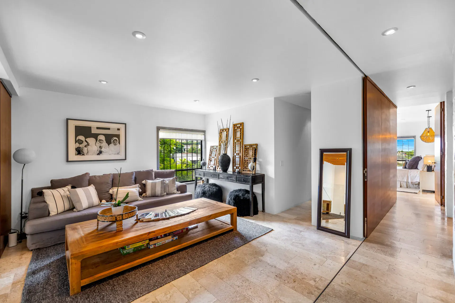 Casa Dos Gatos, upper sitting room with a brown sofa, a wood coffee table and a sliding wood door, San Miguel de Allende