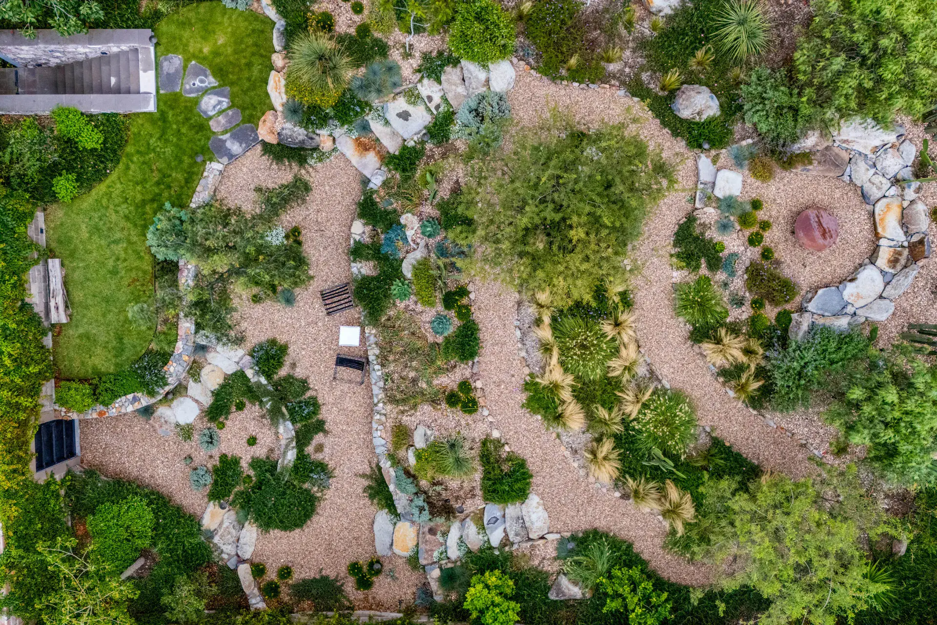 Casa Dos Gatos, aerial view of the winding gravel garden paths, boulders and a stone fire pit, San Miguel de Allende