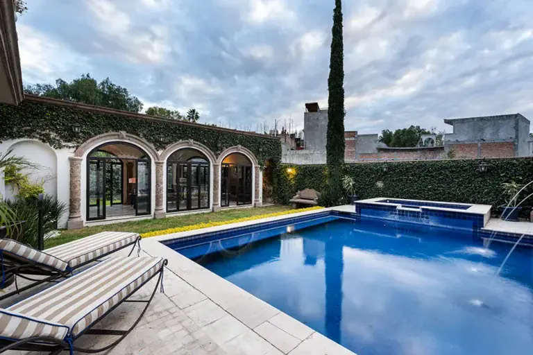 Casa Elegante, courtyard pool with arched glass doors at dusk, San Miguel de Allende