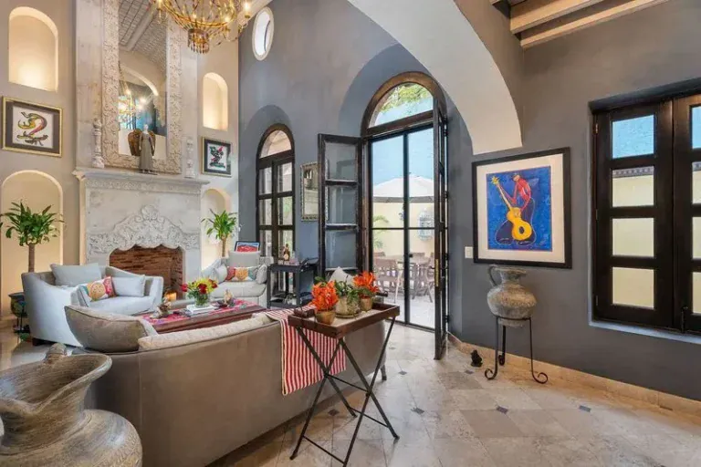 Casa Elegante, living room with a stone fireplace and arched glass doors, San Miguel de Allende
