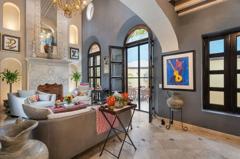 Casa Elegante, living room with a stone fireplace and arched glass doors, San Miguel de Allende