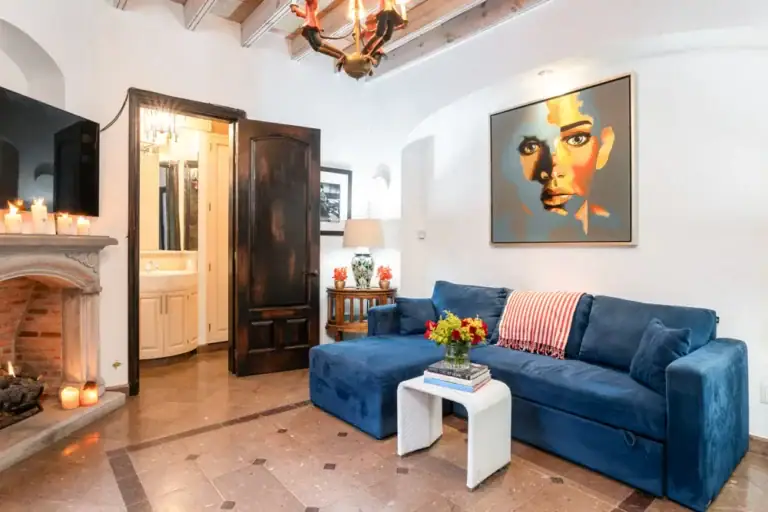 Casa Elegante, sitting room with a blue sectional and a corner fireplace, San Miguel de Allende