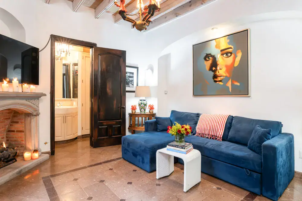 Casa Elegante, sitting room with a blue sectional and a corner fireplace, San Miguel de Allende