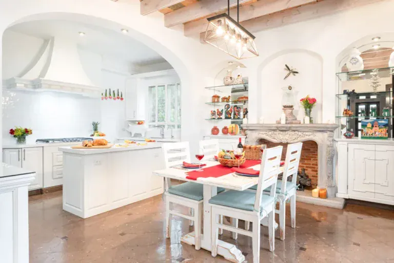 Casa Elegante, kitchen with white cabinets, an island and a stone fireplace, San Miguel de Allende