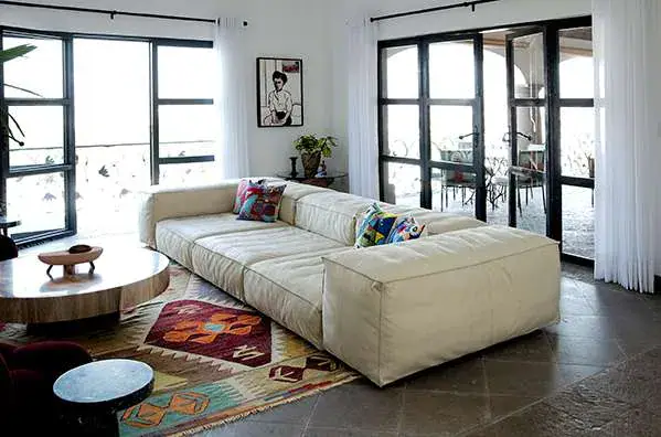 Casa Eloísa, living room with a long cream sofa and tall glass doors, San Miguel de Allende