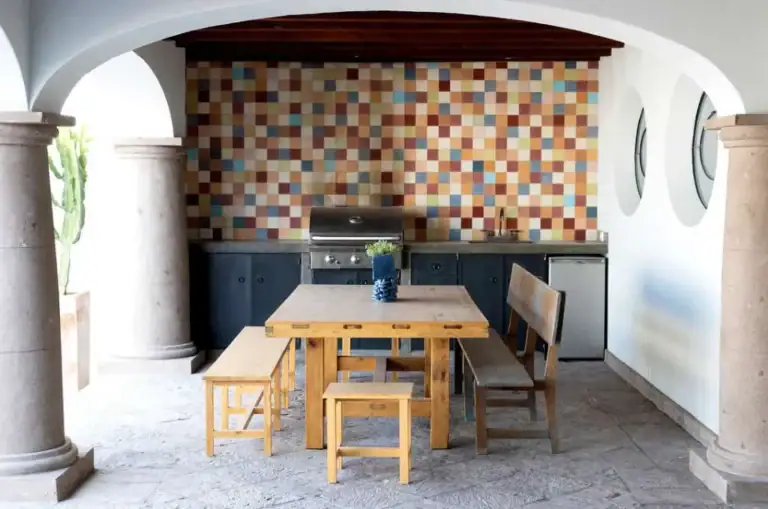 Casa Eloísa, covered outdoor kitchen with a patchwork tile wall and a wood dining table, San Miguel de Allende