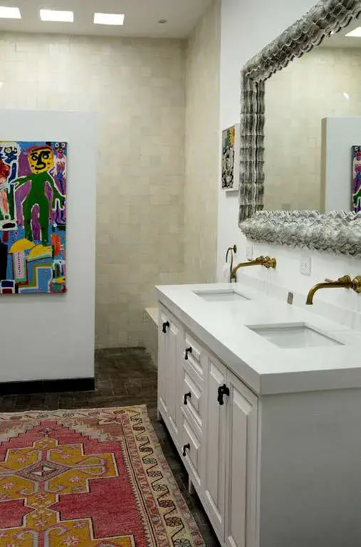 Casa Eloísa, bathroom with a double vanity, a carved mirror and a kilim runner, San Miguel de Allende