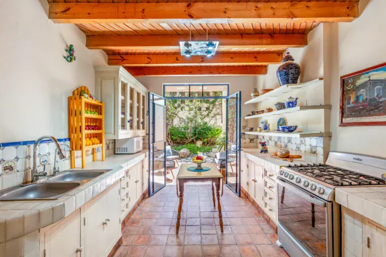 Casa Fallingwater, kitchen with a gas range, open shelves and doors to the garden, San Miguel de Allende