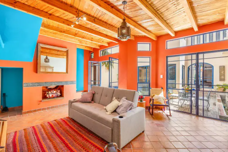 Casa Fallingwater, living room with an orange wall, a sofa bed and a tile floor, San Miguel de Allende