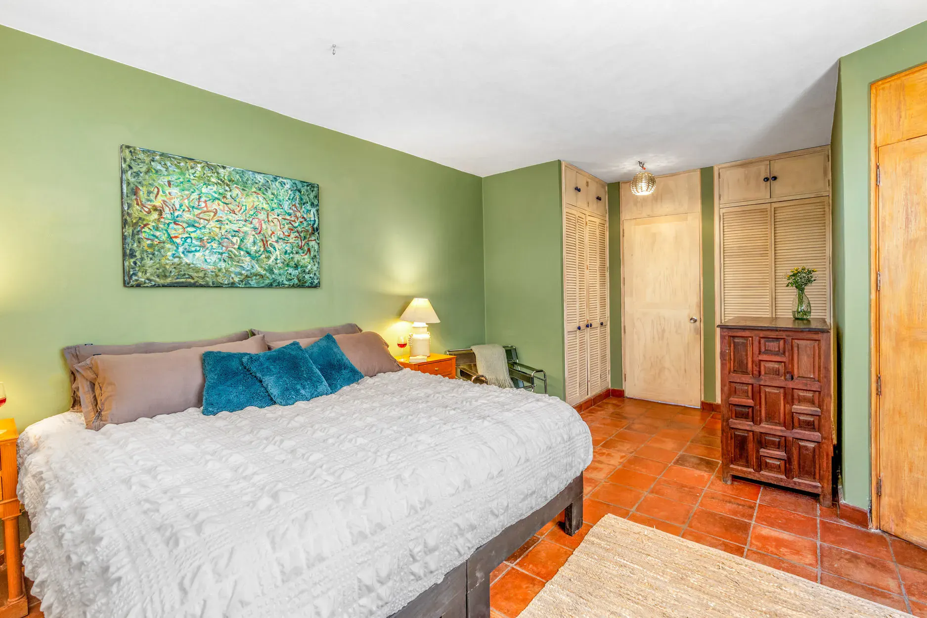 Casa Fallingwater, bedroom with sage green walls and a white bedspread, San Miguel de Allende