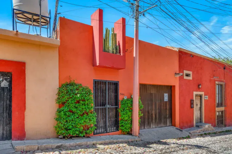 Casa Fallingwater, orange and red street facade on a cobblestone street, San Miguel de Allende