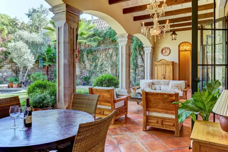 Casa Familia, covered loggia lounge with wicker furniture and a round table, San Miguel de Allende