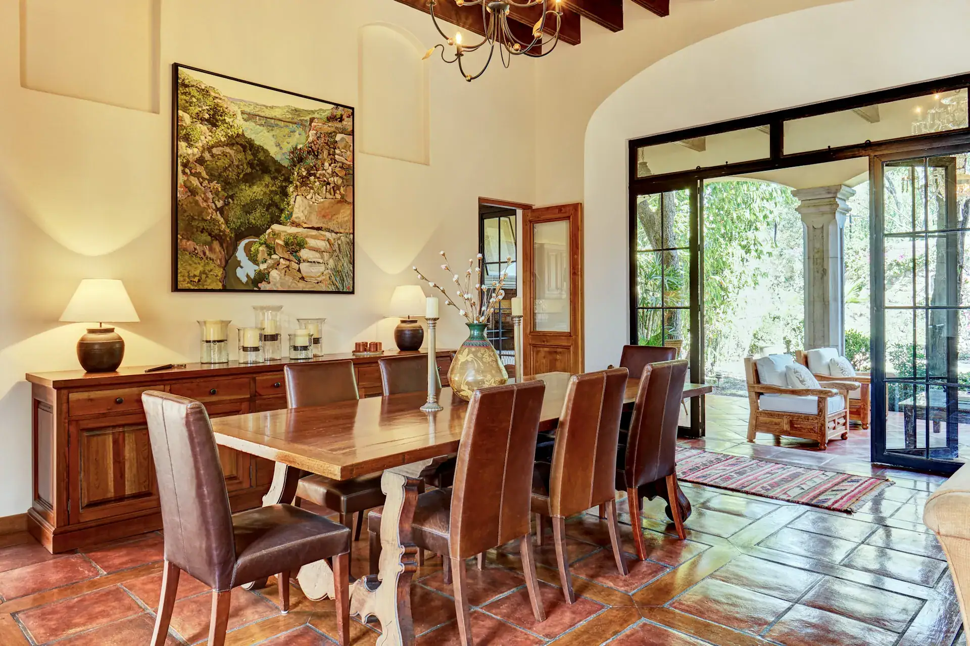 Casa Familia, dining room with a wood table, leather chairs and glass doors, San Miguel de Allende