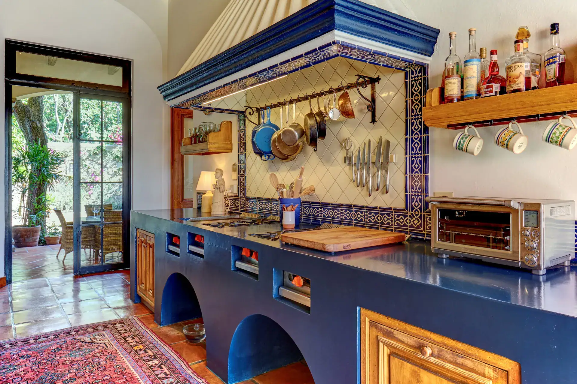 Casa Familia, kitchen with a blue counter, pot rack and tile backsplash, San Miguel de Allende