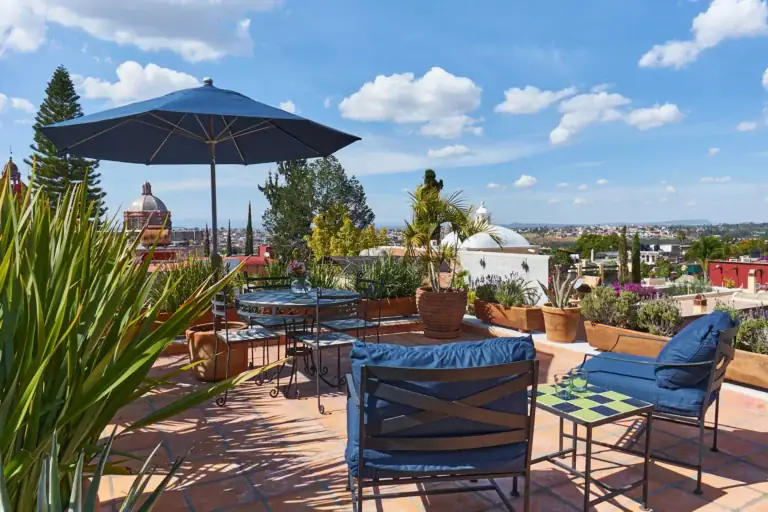 Casa Familia, terrace with a blue umbrella, patio chairs and a view of the Parroquia, San Miguel de Allende