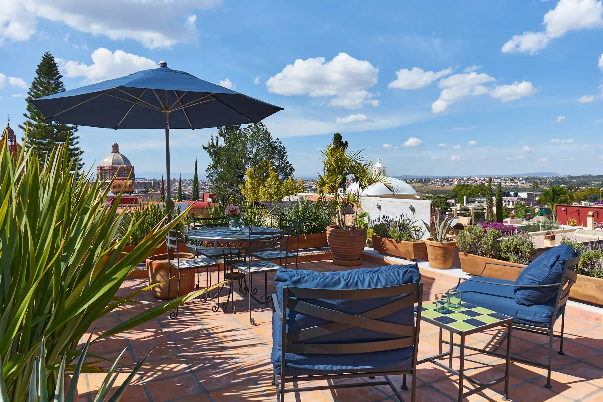 Casa Familia, terrace with a blue umbrella, patio chairs and a view of the Parroquia, San Miguel de Allende