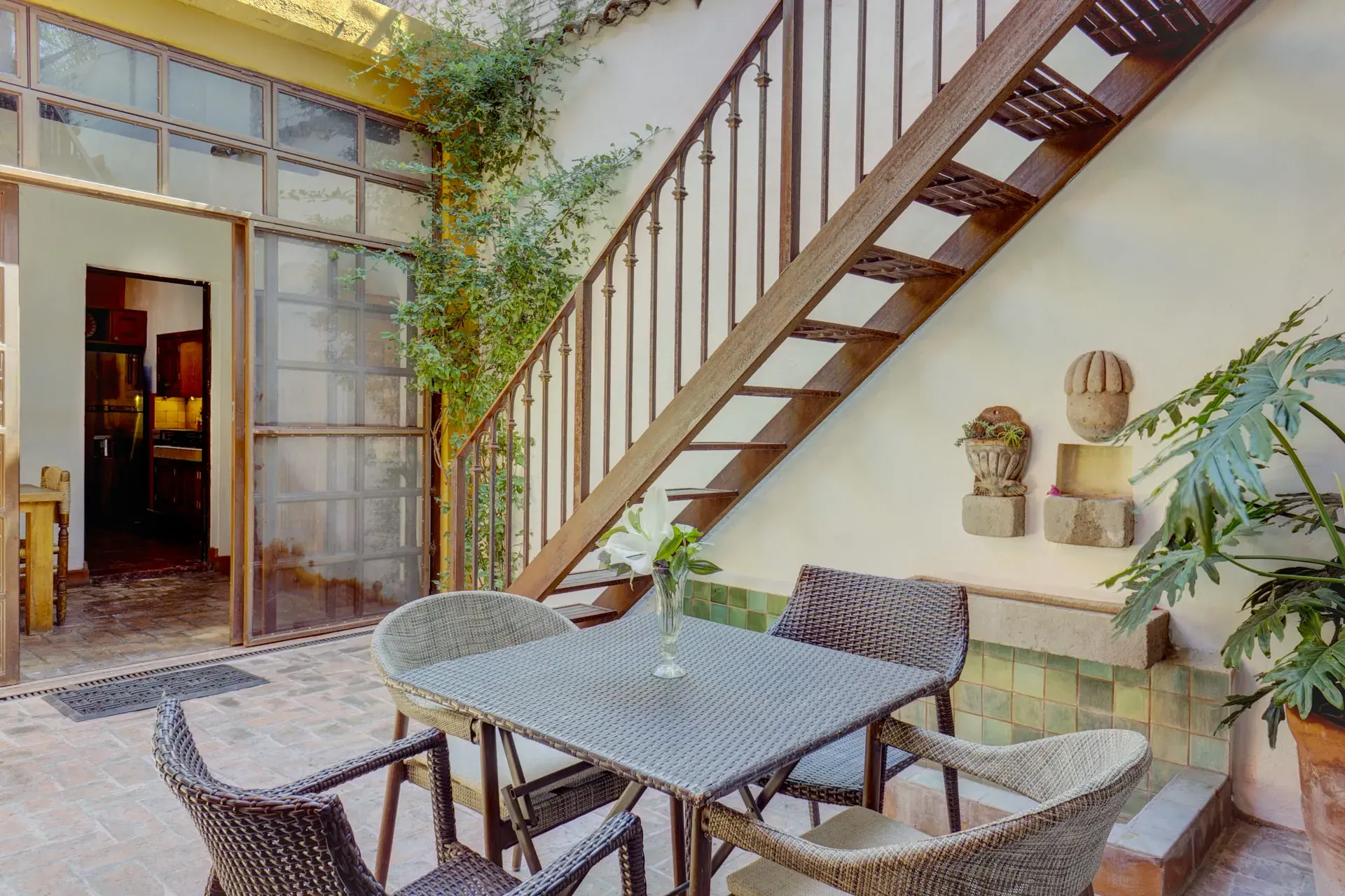 Casa Firenze, courtyard with a bistro table, a wooden staircase and climbing plants, San Miguel de Allende